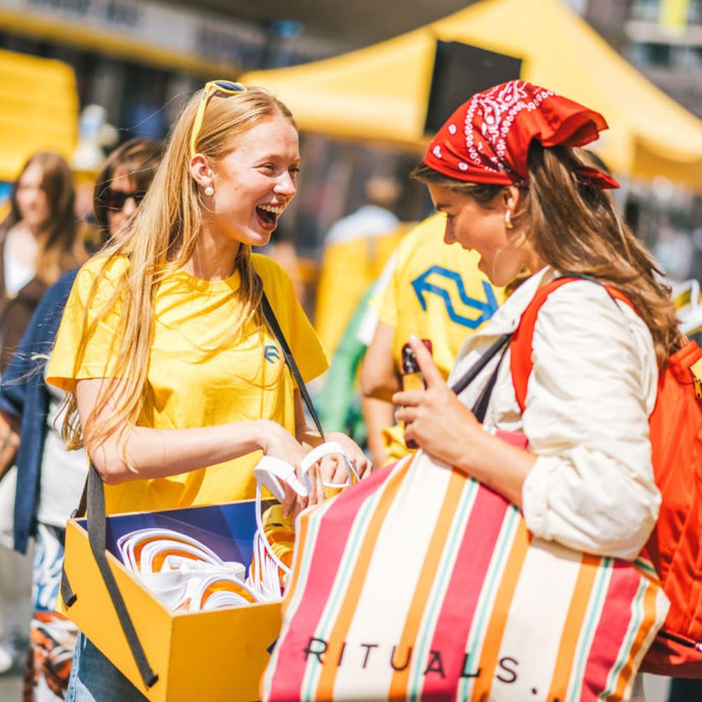 NS-medewerker deelt tasjes uit op een evenement